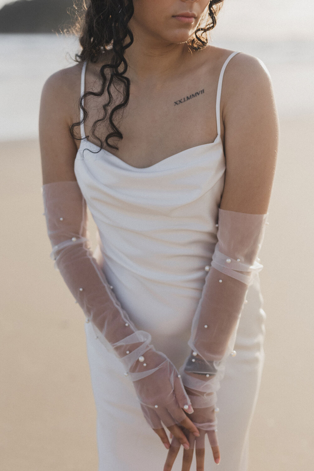 Close-up of pearl detailing on tulle bridal gloves